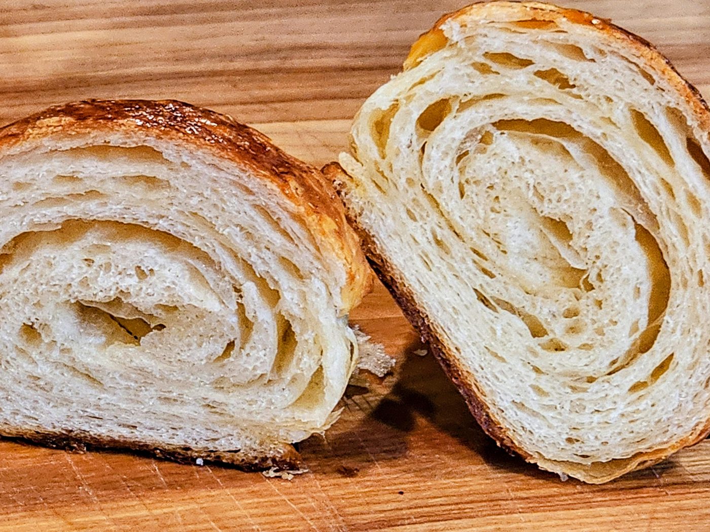 Two croissant halves cut open showing concentric laminated layers